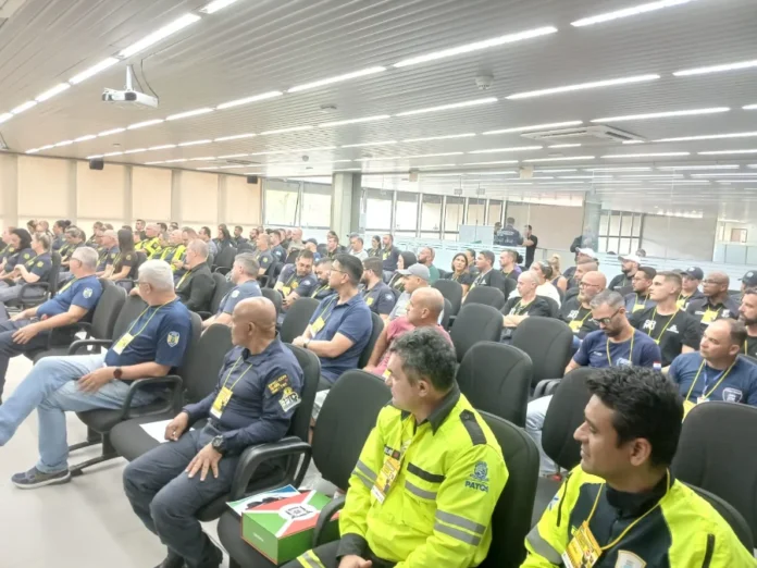 Araranguá participa de encontro estadual de trânsito Fotografia em ângulo aberto de um auditório repleto de agentes de trânsito uniformizados, sentados em poltronas pretas, acompanhando as atividades do encontro estadual em Criciúma.