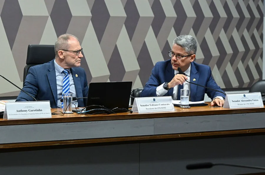 O senador Alessandro Vieira (à direita), relator da CPI do Crime Organizado, sentado à mesa diretora durante uma sessão da comissão no Senado Federal. Ele é o autor do requerimento para o depoimento de TH Joias, mencionado na matéria.