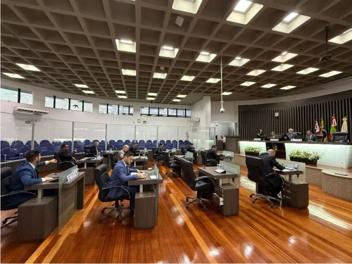 Câmara de Araranguá aprova criação da Vaga Azul Vista ampla do plenário moderno da Câmara Municipal de Araranguá durante a realização da quarta sessão ordinária de fevereiro. Vários vereadores estão sentados em suas mesas individuais no plenário, enquanto a mesa diretora preside os trabalhos ao fundo, em uma noite marcada pela aprovação de projetos sobre mobilidade urbana e infraestrutura.