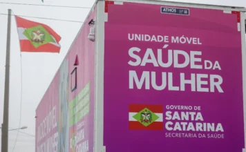 Carretas da Saúde realizam 8,8 mil exames em Santa Catarina A imagem mostra uma das Carretas da Saúde da Mulher, uma unidade móvel do Governo de Santa Catarina, com a inscrição "UNIDADE MÓVEL SAÚDE DA MULHER" e o brasão do estado. O veículo, que percorre diversas regiões oferecendo exames de mamografia e ultrassonografia, tem a bandeira de Santa Catarina hasteada ao fundo.