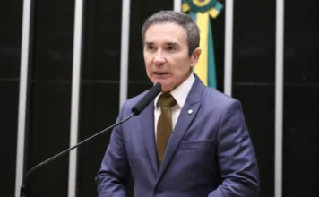 Condomínios deverão denunciar maus-tratos a animais Fotografia do deputado federal Duda Ramos (MDB-RR) falando ao microfone no plenário da Câmara dos Deputados. Ele veste um terno azul, gravata dourada e está posicionado à frente de uma bancada preta com o mastro da bandeira do Brasil ao fundo.