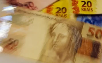 FGC antecipa pagamento de R$ 1 mil para clientes Will Bank Imagem desfocada de cédulas de real brasileiras, incluindo notas de 50, 20 e 2 reais, ilustrando a movimentação financeira e a antecipação de recursos do Fundo Garantidor de Créditos para clientes do Will Bank.