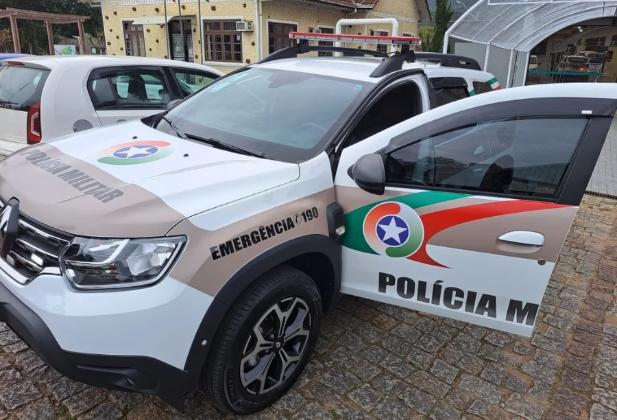 Viatura da Polícia Militar de Santa Catarina estacionada em frente a uma edificação. O veículo, do modelo SUV e de cor branca, apresenta a identidade visual da corporação com faixas em cinza e vermelho, além do brasão oficial e o número de emergência 190 em destaque na lateral. A imagem contextualiza a atuação da PM na ocorrência de tentativa de homicídio em Sombrio.