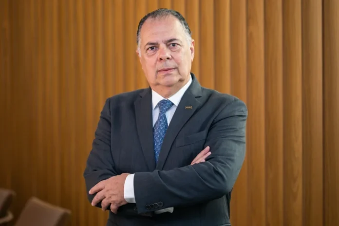 Indústria de SC alerta para riscos do fim da escala 6x1 Retrato de Gilberto Seleme, presidente da FIESC, com expressão séria e braços cruzados, ilustrando a posição de cautela da indústria catarinense em relação ao debate sobre o fim da jornada de trabalho 6x1.