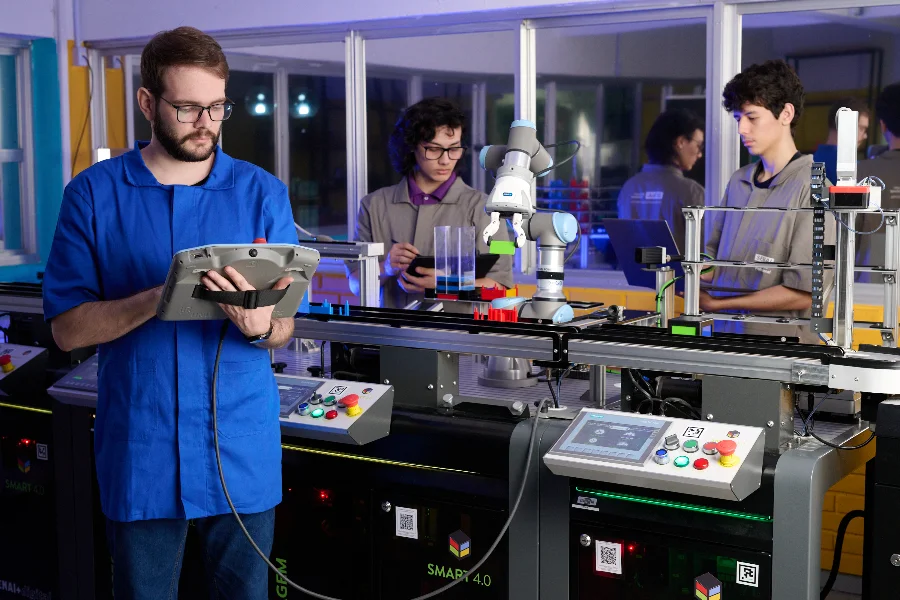Estudantes de aprendizagem industrial realizam atividades práticas com tecnologia de automação e robótica em uma unidade do SENAI em Santa Catarina.