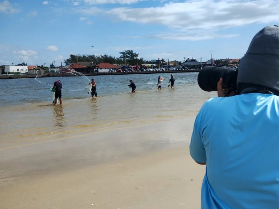 Registro de campo no Rio Tramandaí mostrando a prática da pesca artesanal e o trabalho de monitoramento fotográfico realizado pela equipe do Projeto Botos do Araranguá durante intercâmbio técnico no Rio Grande do Sul.