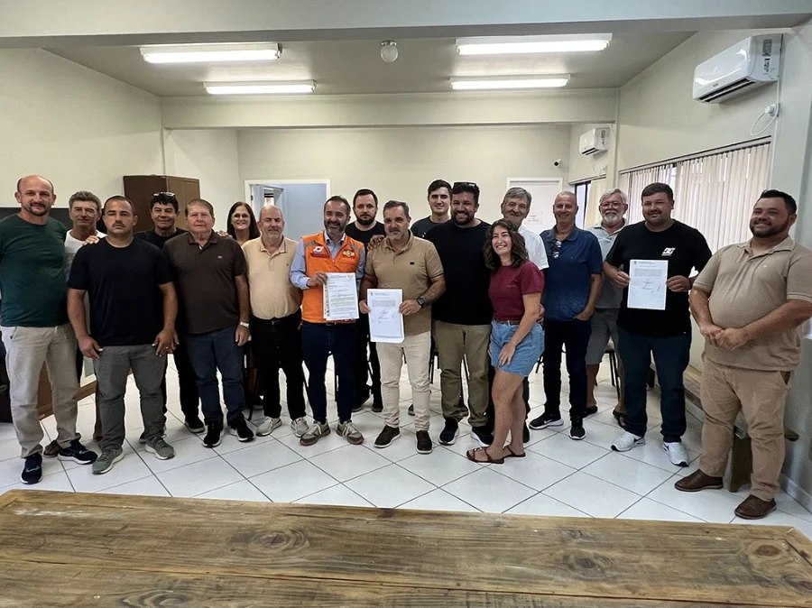Foto em grupo com autoridades municipais de Santa Rosa do Sul, incluindo o prefeito Almides Roberg da Rosa (ao centro, segurando documento), e representantes da Defesa Civil estadual, posando após a assinatura das ordens de serviço para a construção das cabeceiras de quatro novas pontes de concreto.