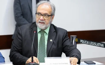 RS terá política contra golpes de falsos advogados O deputado Gustavo Victorino (Republicanos), autor do PL 45/2026 que cria a Política Estadual de Proteção à Identidade Digital da Advocacia para combater golpes em precatórios no RS, é visto discursando em uma comissão legislativa, gesticulando com as mãos sobre a mesa.