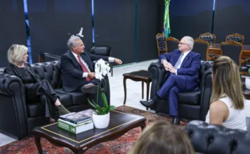 Renan Calheiros pede transparência em caso Banco Master Foto de uma reunião em um gabinete oficial, onde o senador Renan Calheiros (à esquerda, de terno cinza e gravata vermelha) gesticula enquanto conversa com o presidente do STF, ministro Edson Fachin (à direita, de terno azul). Ambos estão sentados em poltronas de couro preto, separados por uma mesa de centro com uma orquídea branca. Outras pessoas, incluindo uma mulher de preto à esquerda e outra de costas em primeiro plano, participam do encontro, que tratou do acesso a investigações sigilosas sobre o Banco Master.