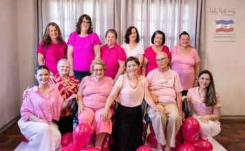Siderópolis é destaque em mostra estadual de saúde Mulheres participantes de uma ação de conscientização do Outubro Rosa em Siderópolis reunidas para uma foto comemorativa, destacando a união na prevenção do câncer de mama.