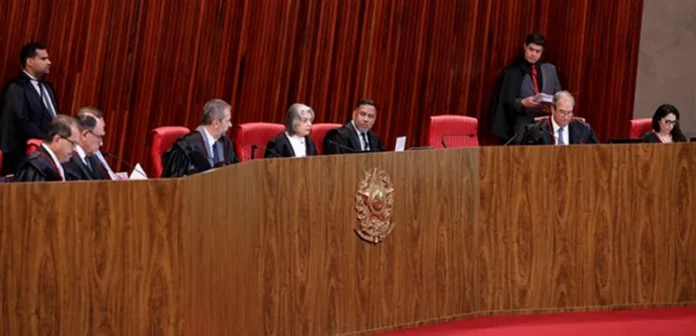 TSE mantém mandato de Jorge Seif por unanimidade Vista geral do Plenário do Tribunal Superior Eleitoral (TSE) durante sessão de julgamento. Os ministros, vestindo togas pretas, estão sentados atrás de uma longa bancada de madeira curva com o brasão da República ao centro, onde decidiram, por unanimidade, manter o mandato do senador Jorge Seif.