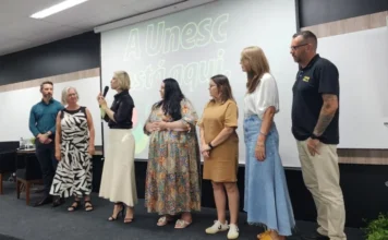 Unesc Araranguá lança cinco novos cursos semipresenciais Reitora Gisele Coelho Lopes e coordenadores de curso no palco da Unesc Araranguá.