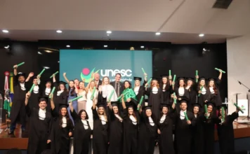 Unesc forma novos psicólogos em cerimônia especial Formandos e autoridades celebram no palco do Auditório Ruy Hülse após a Colação de Grau Especial do curso de Psicologia da Unesc, com os novos profissionais levantando seus diplomas.