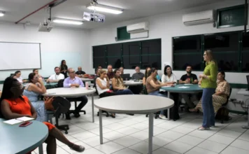 Unesc promove formação docente para o semestre 2026/1 Mulher ministra palestra para grupo de professores em sala de aula, ilustrando atividade do Programa de Formação Docente da Unesc.