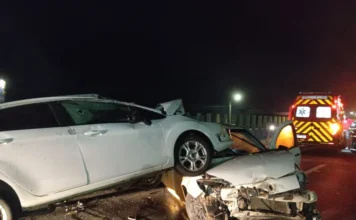 Acidente na BR-101 deixa adolescente ferida em Sombrio Acidente de trânsito na BR-101 em Sombrio mostra um carro branco sobre o outro após colisão noturna. Ao fundo, ambulância do Corpo de Bombeiros com luzes acesas realiza o atendimento da ocorrência no bairro Januária.