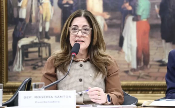 Câmara aprova punição para quem induz jovens a jogos fatais Foto da Deputada Rogéria Santos (Republicanos-BA), relatora do Projeto de Lei que criminaliza desafios virtuais perigosos, falando em comissão na Câmara dos Deputados com microfone.