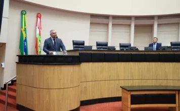 Deputados debatem legítima defesa e proteção de mulheres O deputado estadual Sargento Lima (PL) discursa na tribuna da Assembleia Legislativa de Santa Catarina (Alesc) em Florianópolis. Ele fala sobre o direito à legítima defesa das mulheres contra agressões. No fundo, as bandeiras do Brasil e de Santa Catarina estão penduradas na parede.