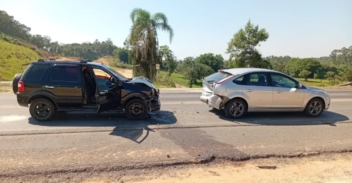 Engavetamento na SC-108 deixa idosa ferida em Cocal do Sul Registro fotográfico de um engavetamento envolvendo dois veículos de passeio na rodovia SC-108, em Cocal do Sul. Um SUV preto apresenta danos na parte dianteira e um hatch prata na traseira, ilustrando a dinâmica da colisão. Marcas de freio e destroços são visíveis na pista de asfalto.