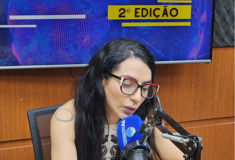 Dra. Araceli Thomaz, cardiologista entrevistada para fazer um alerta sobre a saúde do coração e menopausa, com óculos e tatuagem, falando ao microfone da TV Amorim no estúdio do programa 