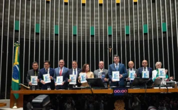 FIESC defende prioridades da indústria no Congresso Presidentes de federações industriais, incluindo Gilberto Seleme da FIESC e Ricardo Alban da CNI, posam no Plenário da Câmara dos Deputados em Brasília durante o lançamento oficial da 31ª Agenda Legislativa da Indústria, segurando cópias do documento que delineia as prioridades do setor industrial brasileiro para políticas públicas.