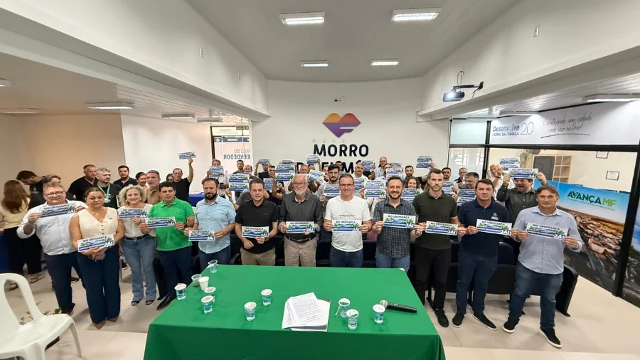 Lideranças políticas e prefeitos do Sul catarinense reunidos em Morro da Fumaça segurando cartazes com os dizeres 