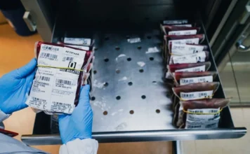 Hemosc registra queda em doações de sangue em Santa Catarina Profissional de saúde com luvas azuis segura bolsa de sangue do tipo O negativo em frente a uma gaveta de armazenamento em unidade do Hemosc, em Santa Catarina.