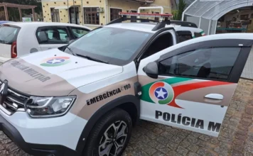 Homem é preso com micro-ônibus adulterado em Orleans Viatura da Polícia Militar de Santa Catarina (PMSC), modelo Renault Duster, estacionada durante operação policial em Orleans. O veículo oficial apresenta as cores branco, marrom e verde, com o giroflex e adesivos de emergência 190 visíveis em primeiro plano.