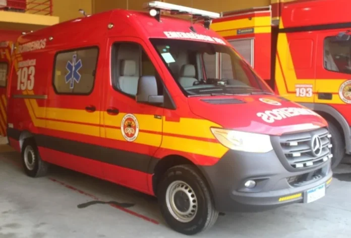 Idoso de 74 anos é reanimado após queda em Passo de Torres Fotografia em plano médio de uma ambulância vermelha do Corpo de Bombeiros Militar de Santa Catarina (CBMSC), modelo Auto Socorro de Urgência (ASU). O veículo está estacionado em uma garagem operacional, apresentando o emblema da corporação na porta e o número de emergência 193 em destaque na lateral e na parte frontal superior.