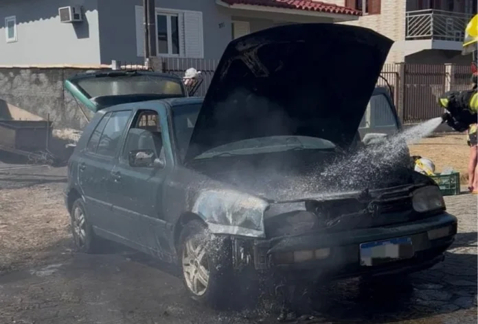 Incêndio atinge carro no bairro Saturno em Forquilhinha Bombeiro militar combate incêndio no compartimento do motor de um Volkswagen Golf verde em Forquilhinha. A imagem mostra o capô aberto com fumaça e o jato de água sendo aplicado para o resfriamento do veículo na Rua das Extremosas.