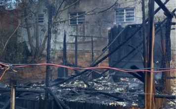 Incêndio destrói residência no bairro Operária, em Araranguá Escombros de residência de madeira totalmente destruída por incêndio no bairro Operária, em Araranguá. A imagem detalha as vigas carbonizadas e os restos da estrutura após o combate às chamas realizado pelo Corpo de Bombeiros (CBMSC).