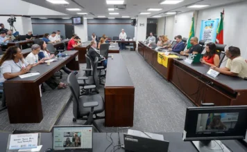 Inclusão escolar é tema de debate na Assembleia do RS Audiência pública sobre inclusão escolar na Comissão de Educação da Assembleia Legislativa do Rio Grande do Sul (ALRS). A imagem mostra parlamentares e representantes de entidades educacionais reunidos em uma sala de comissões, com mesas em formato de "U", laptops e bandeiras do Brasil e do RS ao fundo.