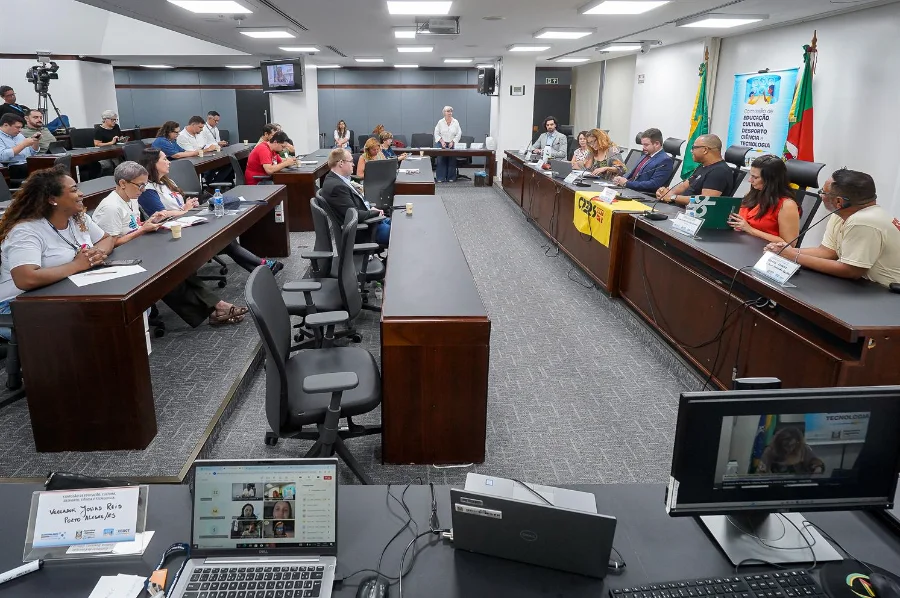 Audiência pública sobre inclusão escolar na Comissão de Educação da Assembleia Legislativa do Rio Grande do Sul (ALRS). A imagem mostra parlamentares e representantes de entidades educacionais reunidos em uma sala de comissões, com mesas em formato de 