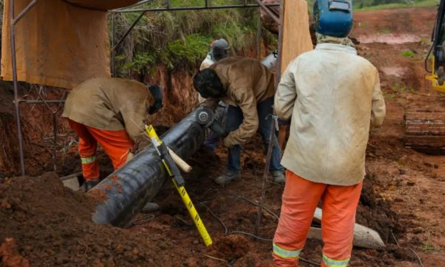 Trabalhadores de obras instalam uma tubulação de gasoduto da SCGÁS em uma vala de terra vermelha, parte da expansão da infraestrutura de gás natural na Serra Catarinense para atender indústrias em Lages e Palmeira.