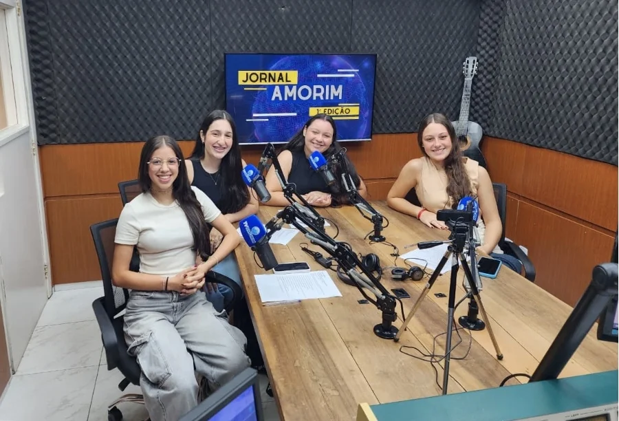 Jovens estudantes Maria Rosa, Maria Clara, Brenda Oliveira e Laisa Zanatta em estúdio de rádio durante debate.