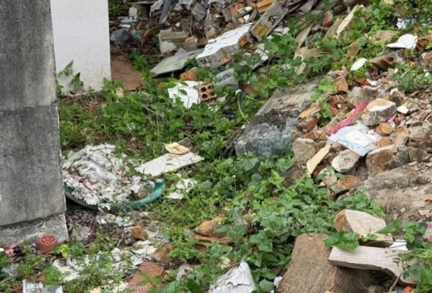 Pilha de entulhos, restos de materiais de constru&ccedil;&atilde;o e lixo descartados em &aacute;rea comum do cemit&eacute;rio municipal.
