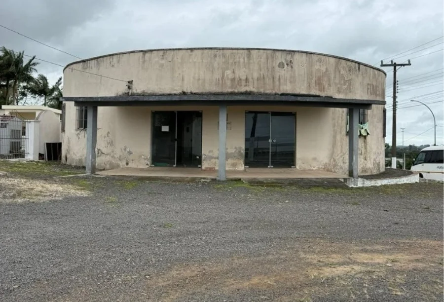 Fachada externa da Capela Mortuária do Cemitério Municipal de Sombrio com paredes sujas e sinais de desgaste na estrutura.
