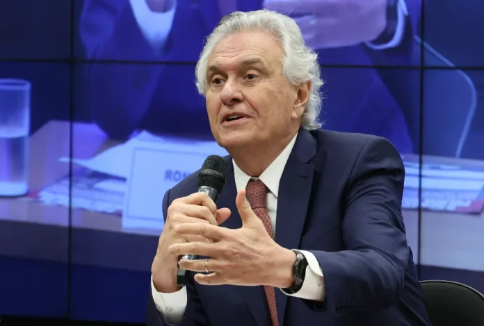 PSD oficializa Caiado como pré-candidato à Presidência O governador de Goiás, Ronaldo Caiado, falando ao microfone durante evento político. Ele veste terno azul escuro e gravata bordô, gesticulando com a mão em um ambiente de conferência.