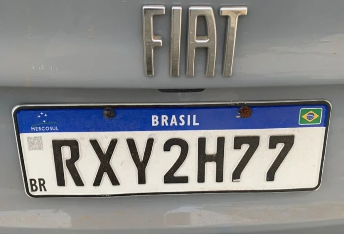 Policial penal é preso com placa clonada em Araranguá Fotografia em close da traseira de um veículo Fiat de cor cinza, focando na placa de identificação modelo Mercosul com o prefixo RXY2H77. A imagem destaca o sinal identificador que motivou a prisão em flagrante do policial penal por adulteração em Araranguá.