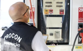 Procon autua postos por diesel abusivo em Criciúma Agente do Procon Criciúma com colete de coordenação inspeciona bomba de combustível durante fiscalização de preços em posto de gasolina.