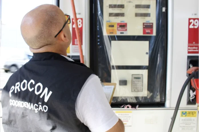 Procon autua postos por diesel abusivo em Criciúma Agente do Procon Criciúma com colete de coordenação inspeciona bomba de combustível durante fiscalização de preços em posto de gasolina.
