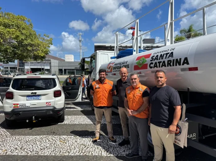 Santa Rosa do Sul recebe verba para prevenção de desastres Prefeito de Santa Rosa do Sul, Almides Roberg da Rosa, e comitiva posam ao lado de novo caminhão-pipa da Defesa Civil de Santa Catarina durante entrega de investimentos em prevenção de desastres.
