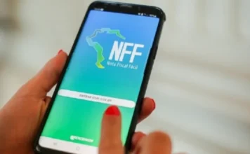 Sefaz RS lança tutoriais sobre Nota Fiscal Fácil para produtor Mãos de uma mulher segurando um smartphone que exibe a tela de login do aplicativo Nota Fiscal Fácil (NFF) para produtores rurais, com o logotipo da Procergs e o botão "ENTRAR COM GOV.BR" visíveis.