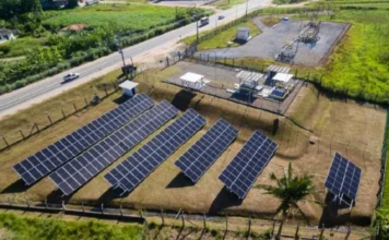 Usina solar da SCGÁS reduz custos em mais de R$ 112 mil Vista aérea da usina solar da SCGÁS em Santa Catarina, com fileiras de painéis fotovoltaicos instalados em área gramada próxima a infraestrutura de gás natural para geração de energia limpa e descarbonização.