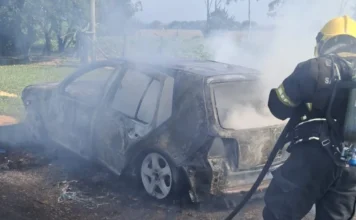 Veículo pega fogo em Araranguá e mobiliza bombeiros Bombeiro militar combatendo incêndio em automóvel Volkswagen Golf no bairro Rio dos Anjos, em Araranguá. O veículo está tomado por fumaça e apresenta danos severos na estrutura após ser atingido pelas chamas.
