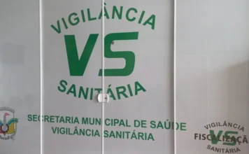 Vigilância de Cocal do Sul alerta para golpe contra comércio Identificação visual da Vigilância Sanitária e Secretaria Municipal de Saúde na fachada de vidro do órgão público em Cocal do Sul, Santa Catarina.
