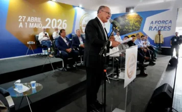 Alckmin anuncia R$ 10 bilhões para máquinas na Agrishow Geraldo Alckmin discursa em púlpito na abertura da Agrishow 2026, em Ribeirão Preto, com painel ao fundo indicando a data do evento e o slogan "A força de nossas raízes", tratando de investimentos em máquinas agrícolas.