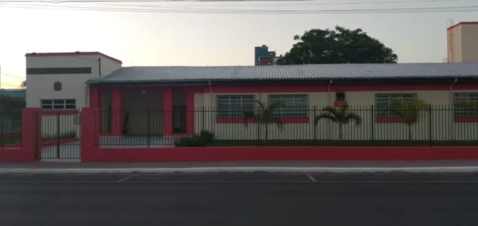 Alesc homenageia 120 anos da Escola Catulo em Sombrio Fachada frontal da Escola de Educação Básica Catulo da Paixão Cearense em Sombrio, Santa Catarina. O prédio de arquitetura clássica nas cores vermelho e branco possui gradis pretos e pequenas palmeiras à frente, representando a centenária instituição que completa 120 anos.