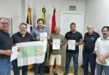 Araranguá terá nova praça no bairro Coloninha Prefeito Cesar Cesa e autoridades de Araranguá seguram a planta do projeto e a ordem de serviço assinada para a construção da nova praça no bairro Coloninha. A imagem destaca o ato oficial de investimento em lazer e infraestrutura urbana no município.
