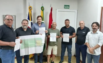 Araranguá terá nova praça no bairro Coloninha Prefeito Cesar Cesa e autoridades de Araranguá seguram a planta do projeto e a ordem de serviço assinada para a construção da nova praça no bairro Coloninha. A imagem destaca o ato oficial de investimento em lazer e infraestrutura urbana no município.