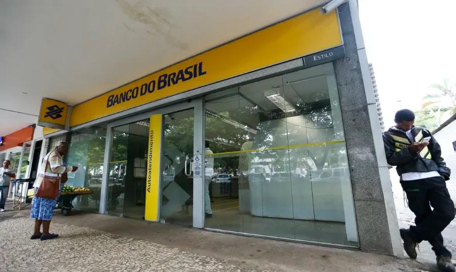Fachada de uma agência do Banco do Brasil com destaque para a entrada de autoatendimento, onde clientes podem realizar a renegociação de dívidas e consultar condições especiais de crédito.